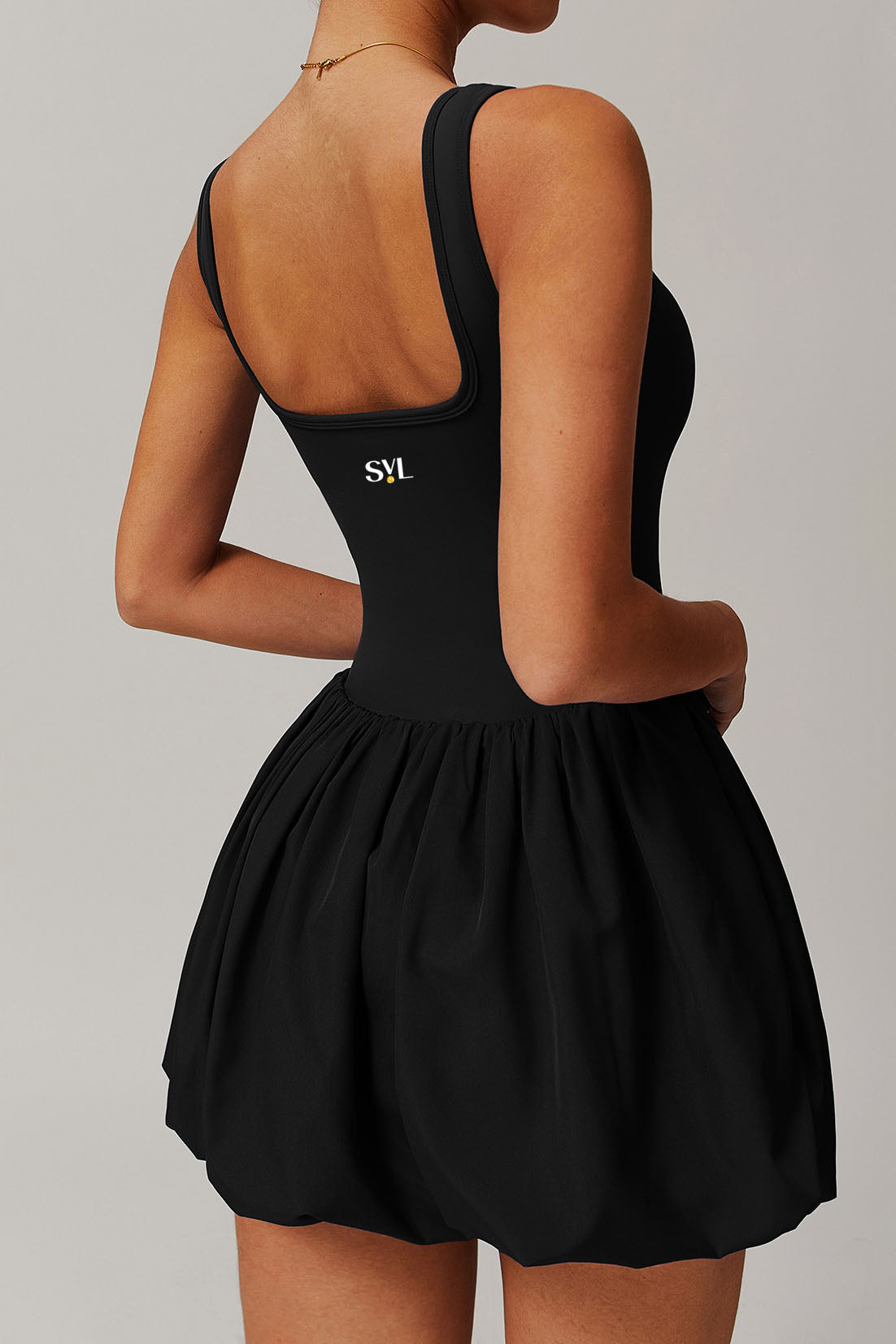 SVL Padel Bubble Belle Dress in black, designed with a playful bubble hem, moisture-wicking fabric, and built-in shorts for stylish performance during padel matches