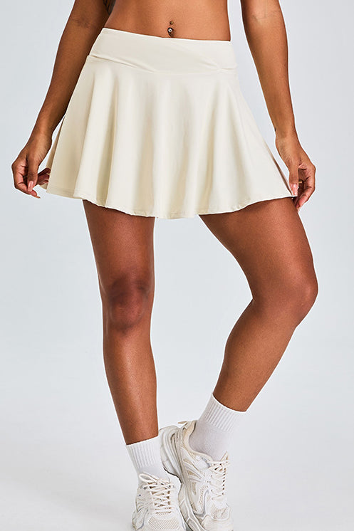 SVL Padel Featherlight & Flow Skirt in ivory, offering a flowy silhouette with built-in shorts, constructed from breathable fabric for optimal performance during padel matches