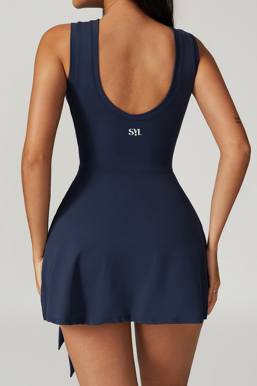SVL Padel Play & Party Dress in dark blue, featuring a chic wrap-tie detail, flattering silhouette, and built-in shorts for versatile wear on and off the padel court