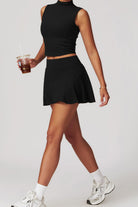 SVL Padel Swan Sway Set in Black – a graceful and performance-focused ensemble featuring a sleeveless, high-neck top paired with a flared skirt with built-in shorts. Designed for elegance, comfort, and agility, this set is crafted from lightweight, breathable fabric with an elastic waistband, ensuring effortless movement and style on the padel court