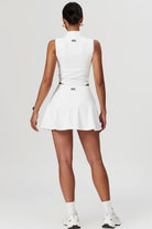 SVL Padel Swan Sway Set in White – a graceful and performance-focused ensemble featuring a sleeveless, high-neck top paired with a flared skirt with built-in shorts. Designed for elegance, comfort, and agility, this set is crafted from lightweight, breathable fabric with an elastic waistband, ensuring effortless movement and style on the padel court