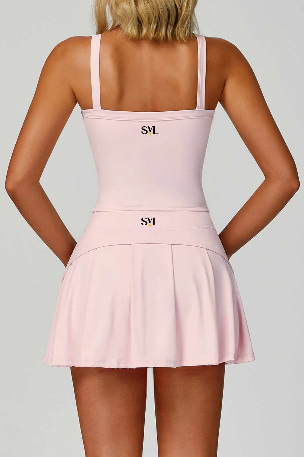 Rear view of the pink SVL Anna padel and tennis skirt highlighting the athletic pleated back design and the SVL brand logo.