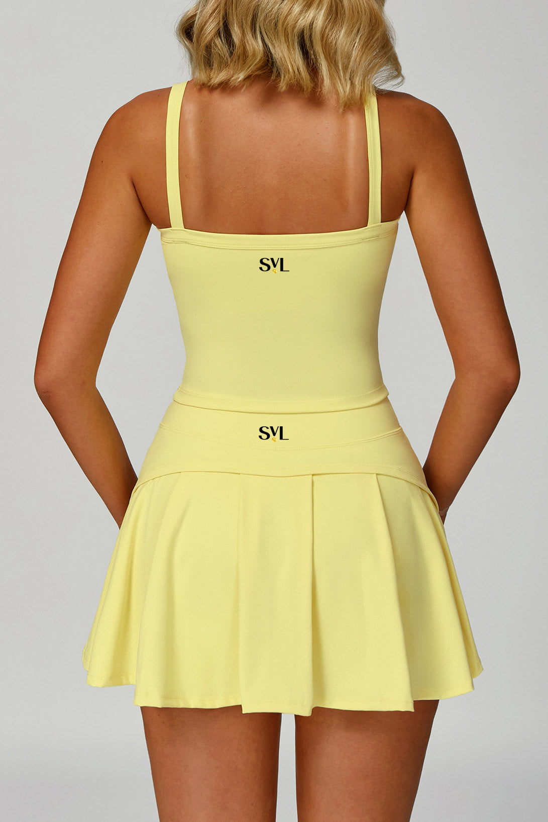 Rear view of the yellow SVL Anna padel and tennis skirt showcasing the back pleats and the SVL logo on the waistband.