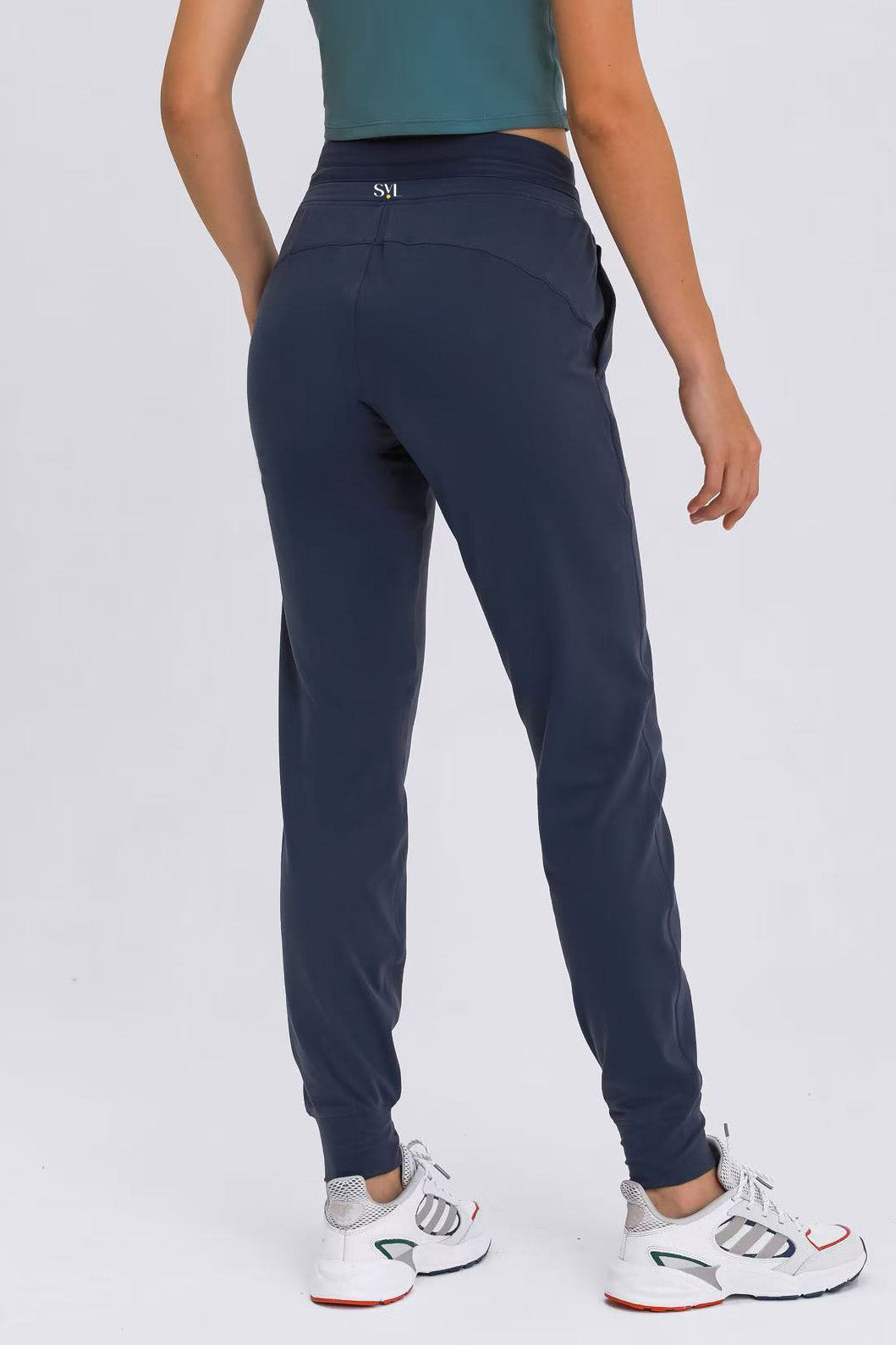 Rear view of the navy blue Arwa sweatpants highlighting the SVL brand logo on the back waistband and the flattering athletic silhouette.