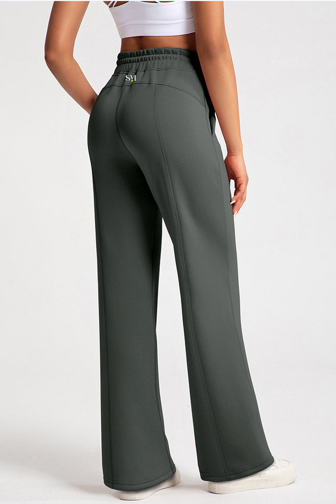 Rear view of the dark grey Salma sweatpants showing the SVL brand logo on the back waistband and the modest, flowing wide-leg design.