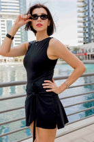 SVL Padel Play & Party Dress in black, featuring a chic wrap-tie detail, flattering silhouette, and built-in shorts for versatile wear on and off the padel court
