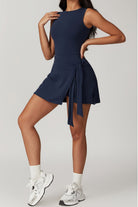 SVL Padel Play & Party Dress in dark blue, featuring a chic wrap-tie detail, flattering silhouette, and built-in shorts for versatile wear on and off the padel court