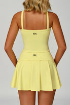 Rear view of the yellow SVL Anna padel and tennis top highlighting the straight-back design and the SVL brand logo.