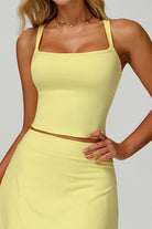 Close-up studio view of the yellow SVL Anna padel and tennis top featuring a modern square neckline and supportive wide straps.