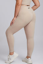 Back view of SVL beige leggings Active Aura high waisted plus size performance leggings with pocket for padel and tennis