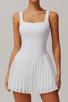 Front studio view of the white Daria performance tennis and padel dress featuring a crisp square neckline and pleated skirt.