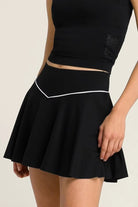 Close-up of the black SVL Kate padel and tennis skirt highlighting the stylish V-shaped white piping on the waistband.