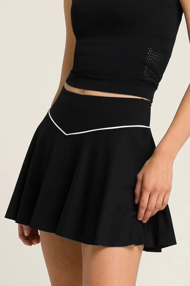 Close-up of the black SVL Kate padel and tennis skirt highlighting the stylish V-shaped white piping on the waistband.