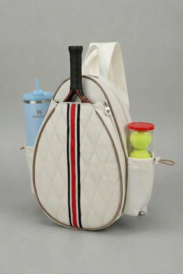 Premium beige quilted SVL padel backpack featuring a central red and black racing stripe, dedicated racket compartment, and side storage for water bottles and balls.
