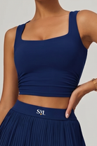 Woman padel player wearing SVL Plush Pleat Navy Blue Padel Set