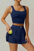 Woman padel player wearing SVL Plush Pleat Navy Blue Padel Set