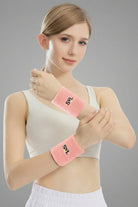 Female padel player wearing SVL pink sports wristbands during padel and tennis training