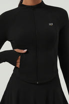 A detail shot of the black Swan Sway tennis jacket highlighting the integrated thumb holes and functional side zipper pockets.