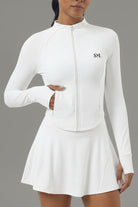 Detail shot of the white Swan Sway performance jacket highlighting the secure side zipper pocket and integrated thumb holes on the sleeves.