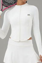Front view of a woman wearing the white Swan Sway performance jacket with a matching white athletic skirt for tennis and padel.