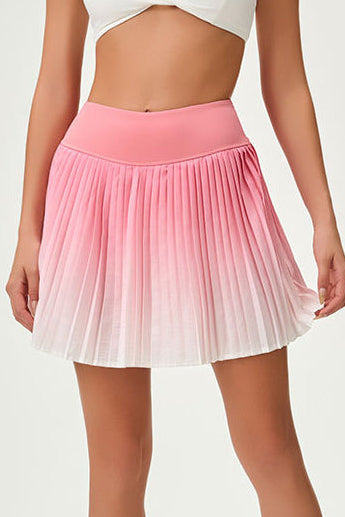 Close-up studio view of the SVL Valeria performance skirt featuring a pink to white ombre gradient and sharp athletic pleats.
