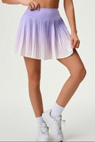 Close-up studio view of the SVL Valeria performance skirt featuring a purple to white ombre gradient and sharp athletic pleats.