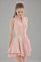 Front studio view of the pink Wiktoria tennis and padel dress featuring a high-neck zip-up bodice and a double-layered flared skirt.